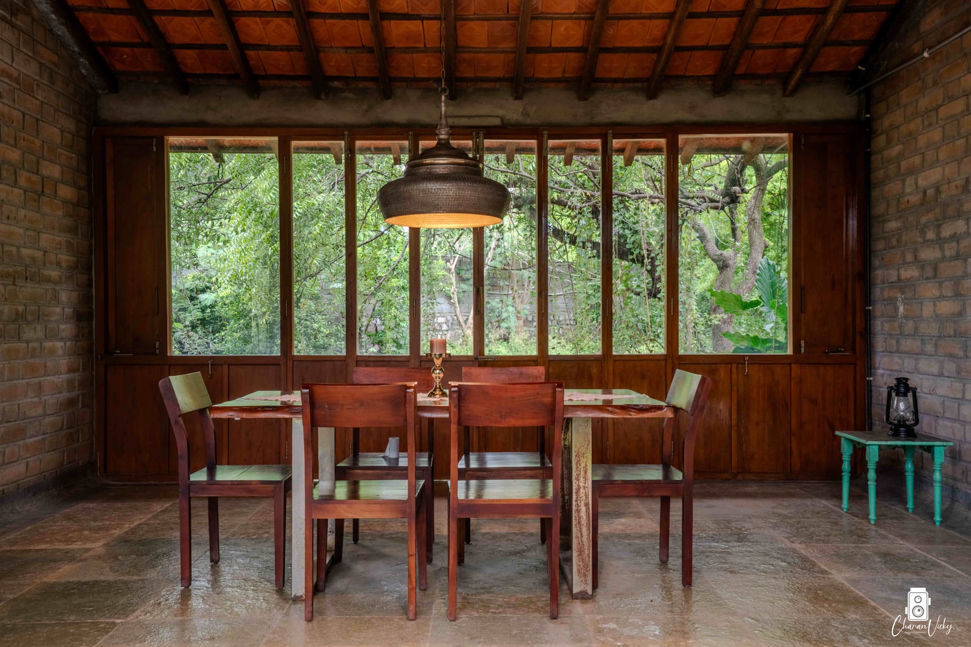 Dining room with brass pendant and forest windows